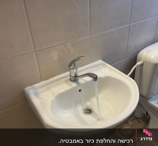 כיור עם מים זורמים בחדר אמבטיה